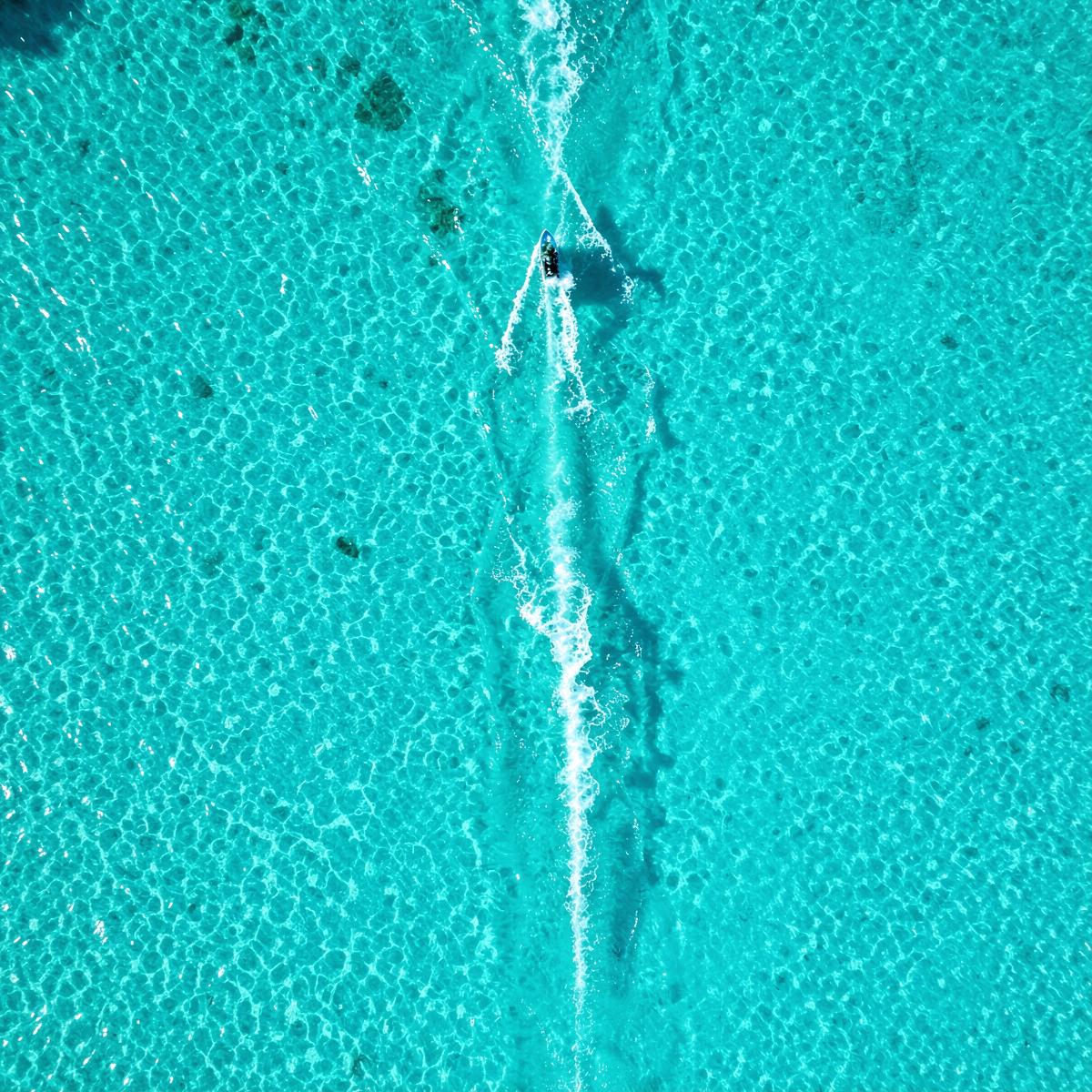Vista aérea do mar turquesa de Coroa Vermelha com rastro de jet ski